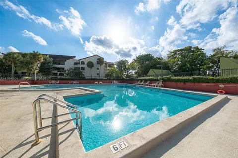 a view of a swimming pool with a yard and plants