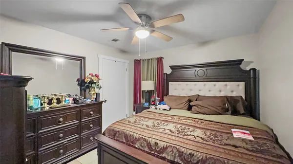 a bedroom with a bed and a potted plant