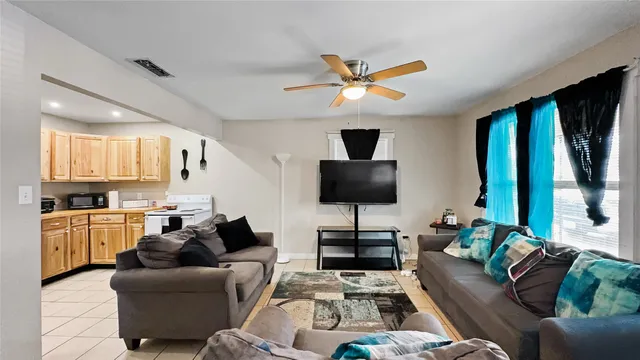 a living room with furniture a flat screen tv and a large window