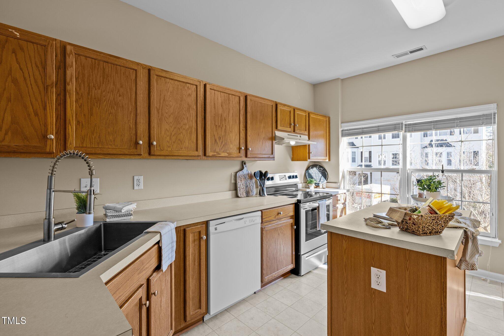 1674 Snow Mass Way Durham, NC 27713 - Photo 19 of 30 a kitchen with stainless steel appliances granite countertop a sink stove and cabinets