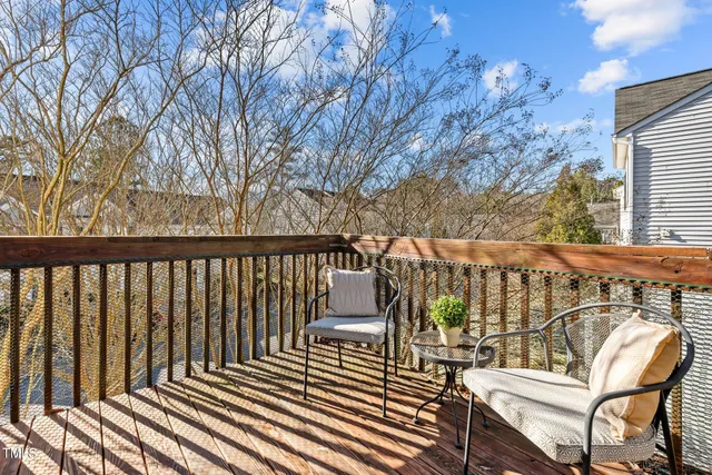 a balcony with wooden floor and outdoor seating