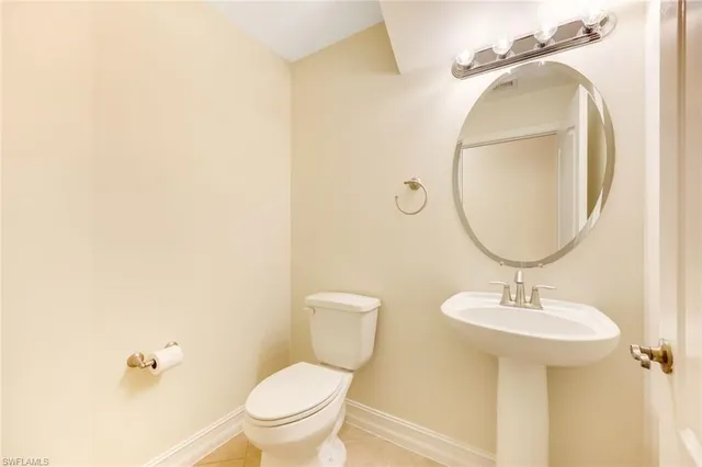 an empty room with a chandelier fan and windows