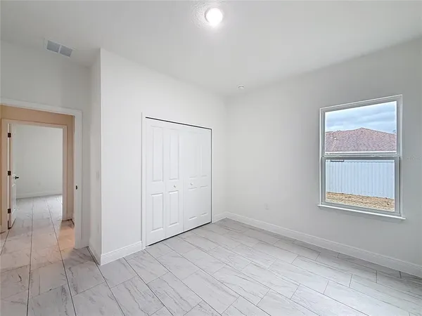 an empty room with a bathroom and a window