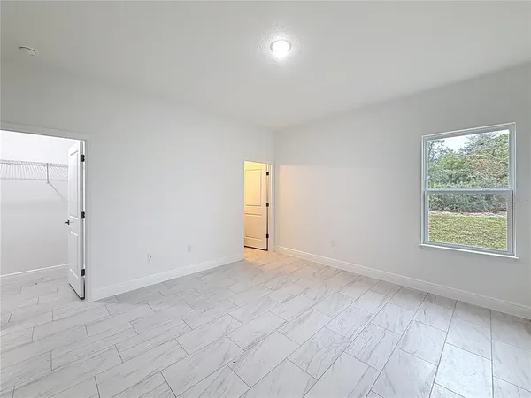 an empty room with windows and closet