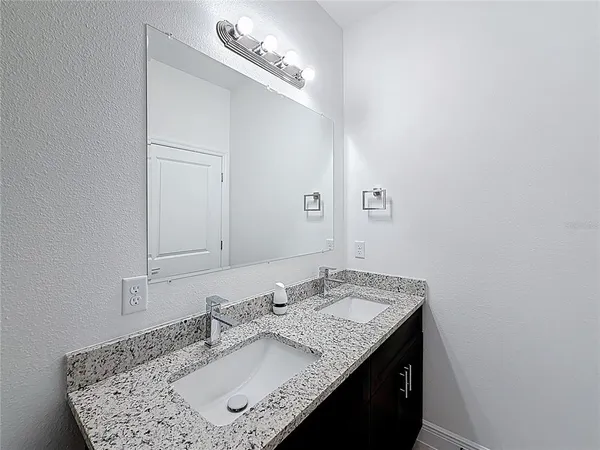 a bathroom with a granite countertop sink and a mirror
