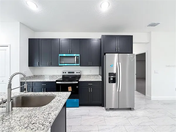 a kitchen with a stove sink and refrigerator