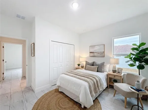 a bedroom with a bed and a potted plant