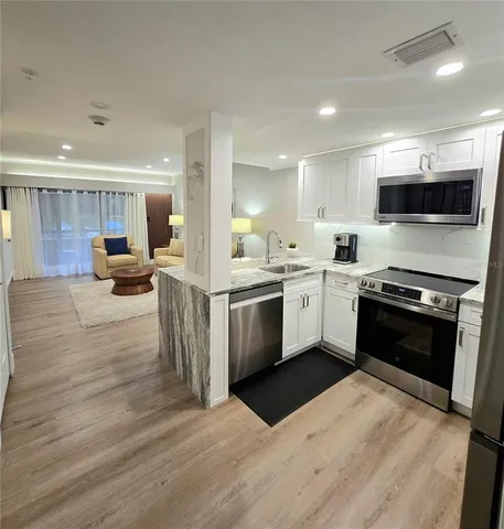 a kitchen with stainless steel appliances kitchen island granite countertop a stove top oven and sink