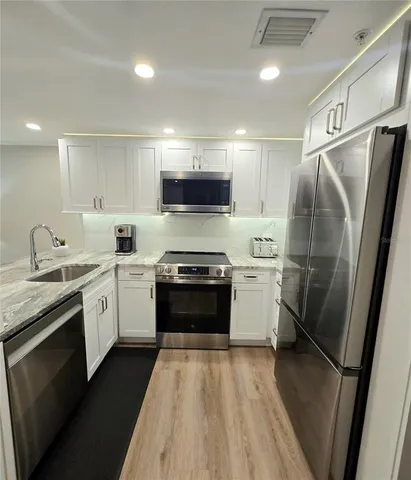 a kitchen with a sink stove and refrigerator