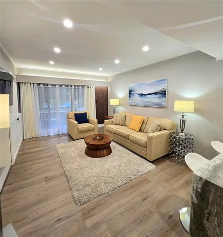 a living room with furniture and a wooden floor