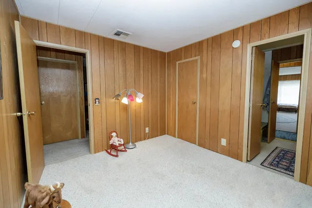 a bedroom with a bed and a painting on the wall