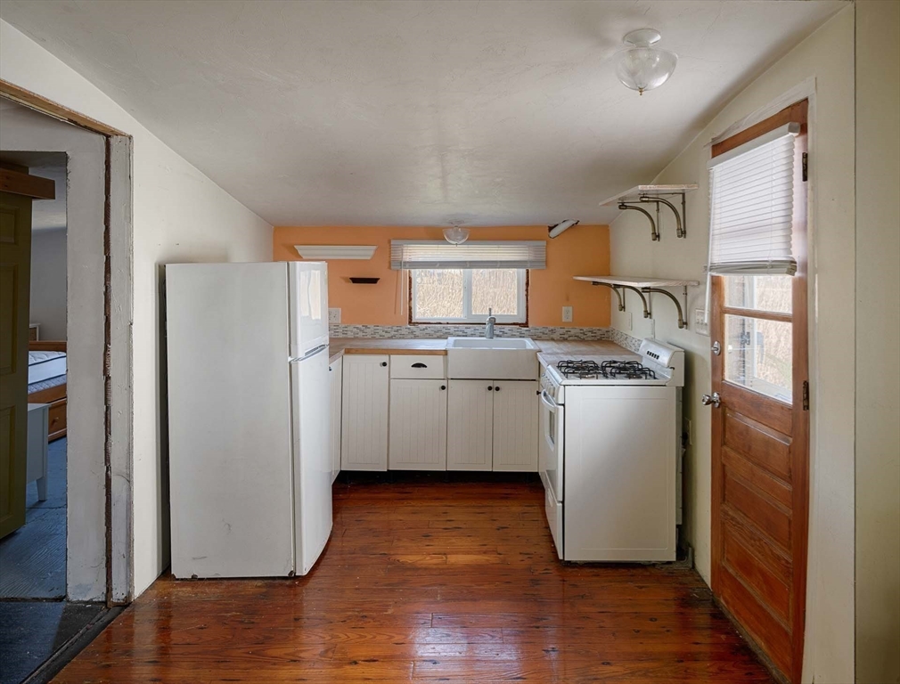 1177 Ferry Street Marshfield, MA 02050 - Photo 7 of 18 a kitchen with a refrigerator sink and cabinets