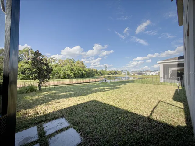 an empty room that has a window and a chandelier fan