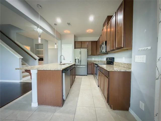 a kitchen with stainless steel appliances granite countertop a refrigerator a stove a sink and a refrigerator