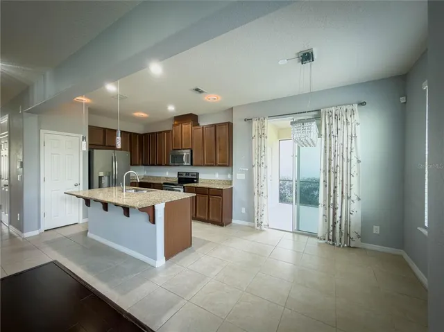 a kitchen with kitchen island a stove a sink and a refrigerator