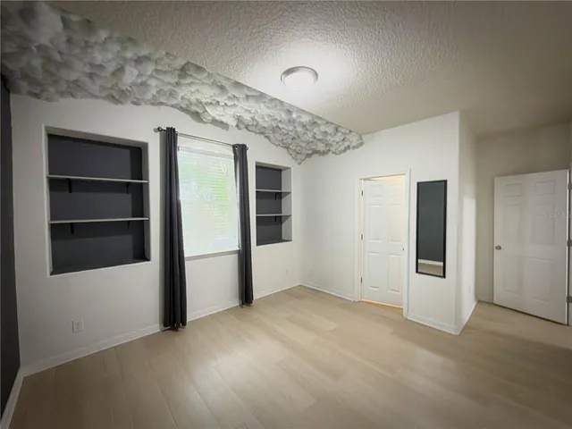 a view of an empty room with a kitchen