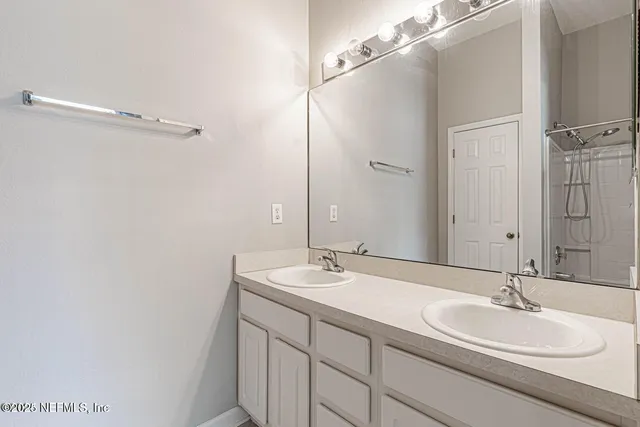 a bathroom with a double vanity sink and mirror