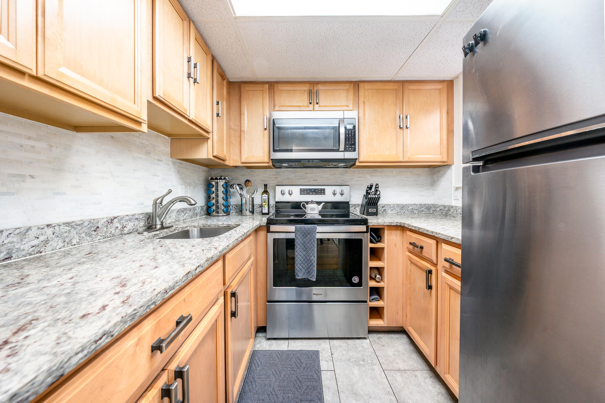 135 West Main Street, Unit 45 Hyannis, MA 02601 - Photo 3 of 23 a kitchen with granite countertop a sink stove and cabinets