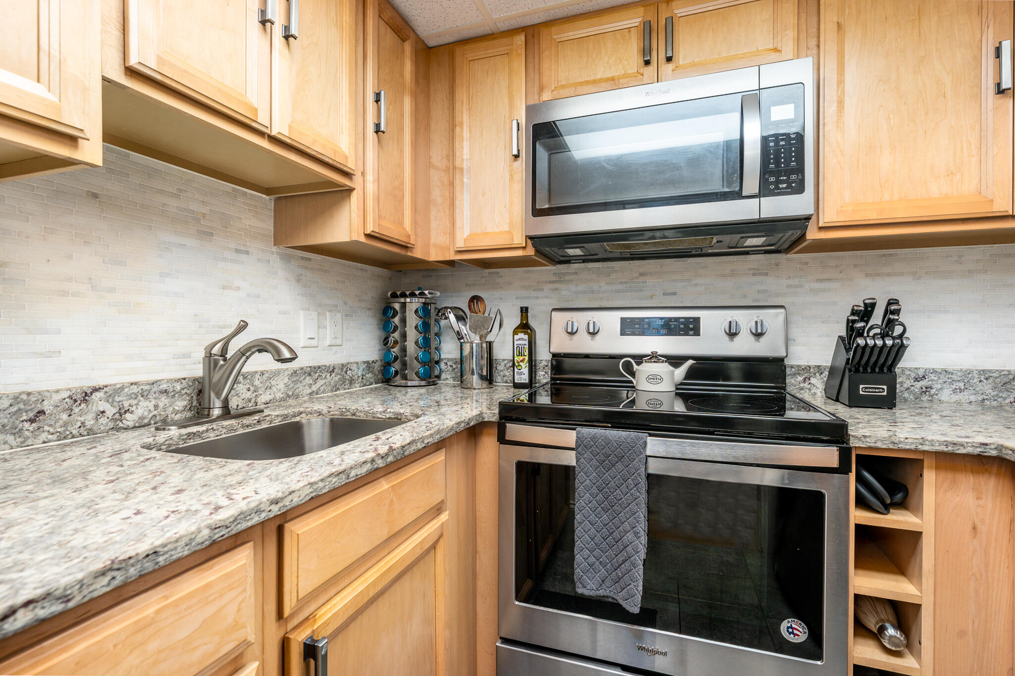 135 West Main Street, Unit 45 Hyannis, MA 02601 - Photo 9 of 23 a kitchen with granite countertop a sink and a stove top oven