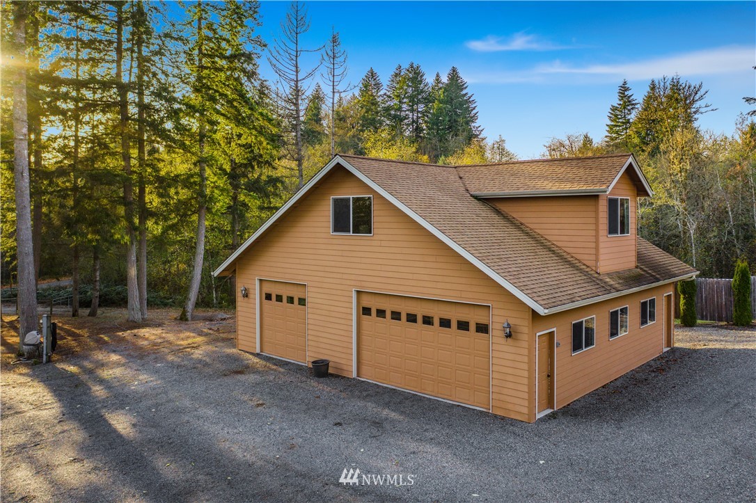 5130 165th Lane Southwest Rochester, WA 98579 - Photo 22 of 25 a view of a house with a yard balcony and trees in the background