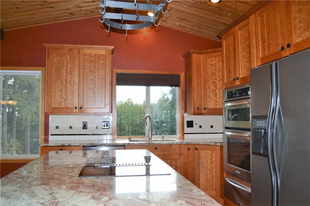 5130 165th Lane Southwest Rochester, WA 98579 - Photo 10 of 25 a kitchen with stainless steel appliances kitchen island granite countertop a refrigerator and microwave