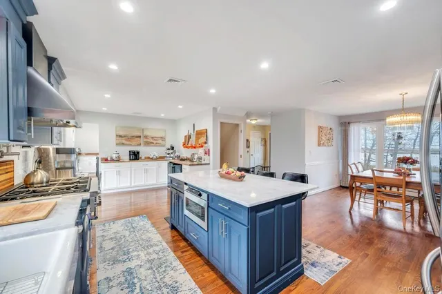 a large kitchen with stainless steel appliances a stove a sink dishwasher and a dining table with the living room view