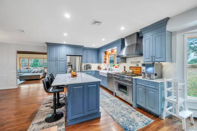 a kitchen with kitchen island granite countertop wooden floors and stainless steel appliances