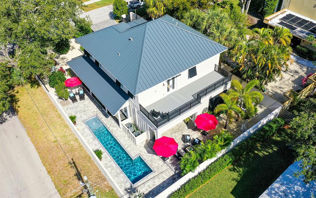 a aerial view of a house swimming pool and red umbrella