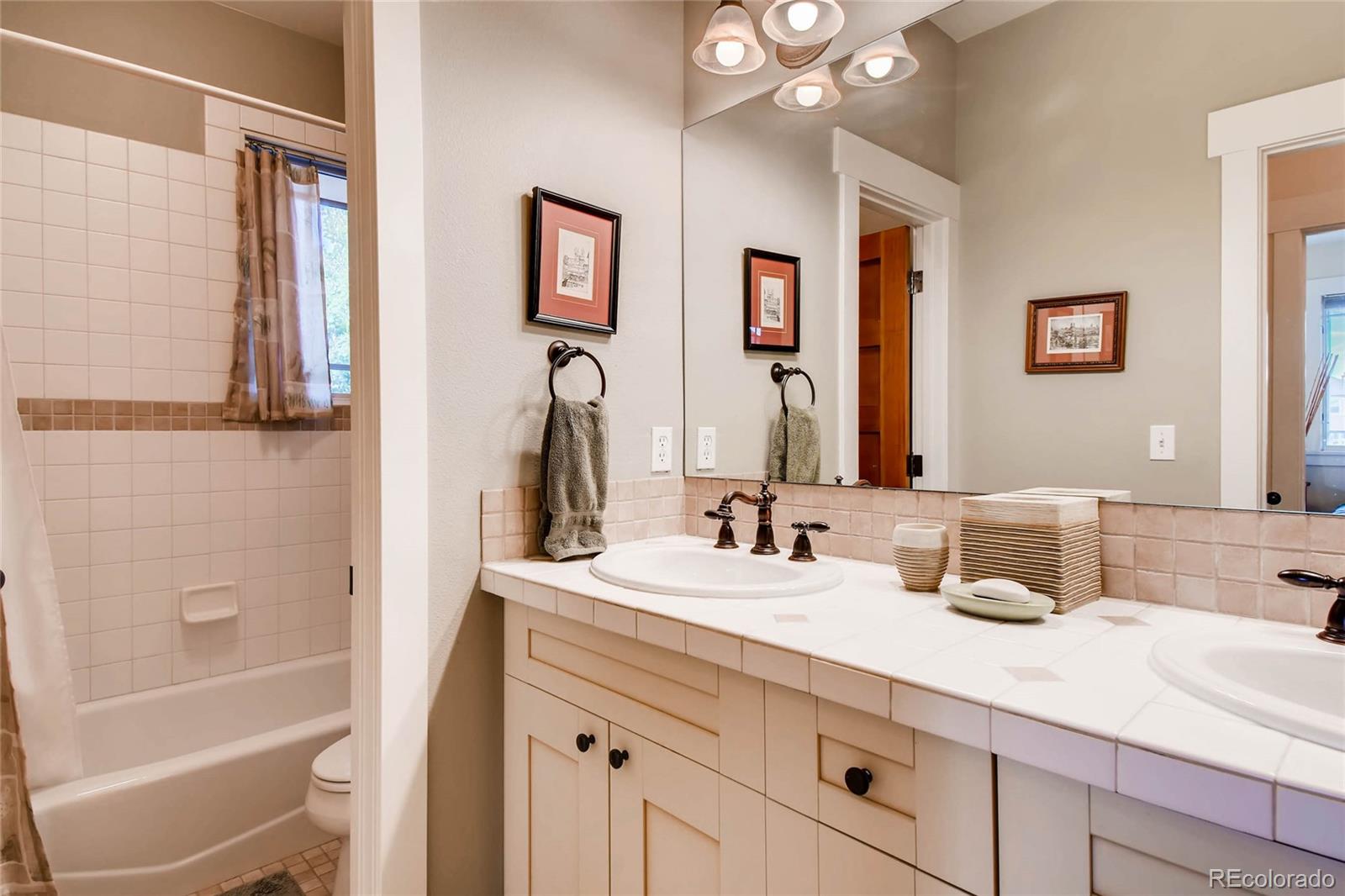 11770 Perry Street Westminster, CO 80031 - Photo 21 of 28 a bathroom with a double vanity sink mirror and bathtub
