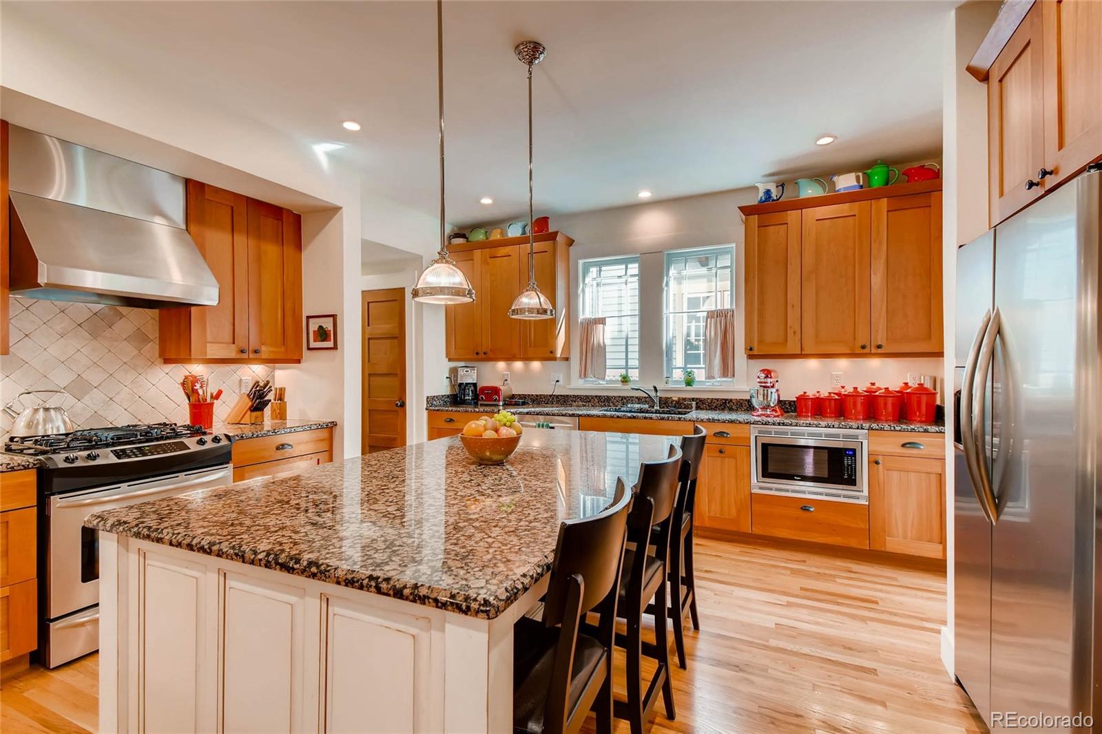 11770 Perry Street Westminster, CO 80031 - Photo 7 of 28 a kitchen with stainless steel appliances granite countertop a kitchen island a stove a sink a dining table and chairs