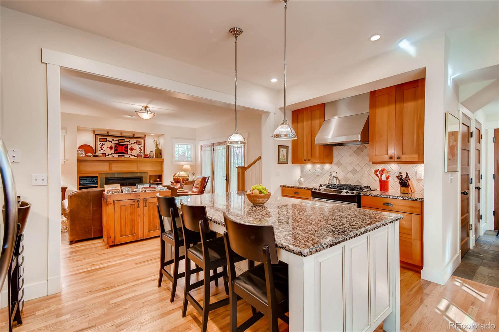 11770 Perry Street Westminster, CO 80031 - Photo 10 of 28 a kitchen with stainless steel appliances granite countertop table chairs and wooden floor