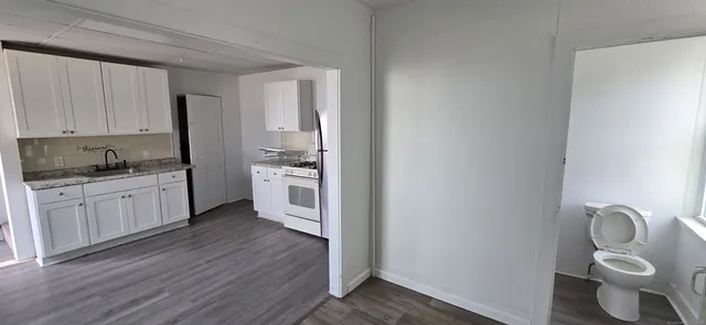 a kitchen with a refrigerator and white cabinets