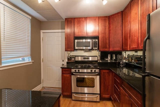 72 Pine Avenue, Unit GDN Riverside, IL 60546 - Photo 5 of 10 a kitchen with granite countertop wooden cabinets stainless steel appliances and a window
