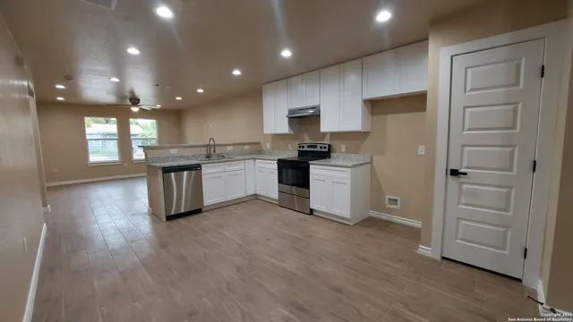 a kitchen with white cabinets and appliances