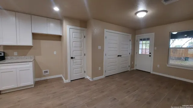 an empty room with closet and windows