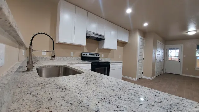 a kitchen with stainless steel appliances granite countertop a sink and a refrigerator