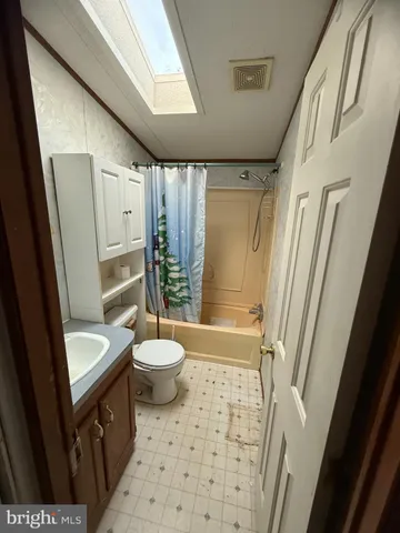 a bathroom with a sink a toilet a tub and shower