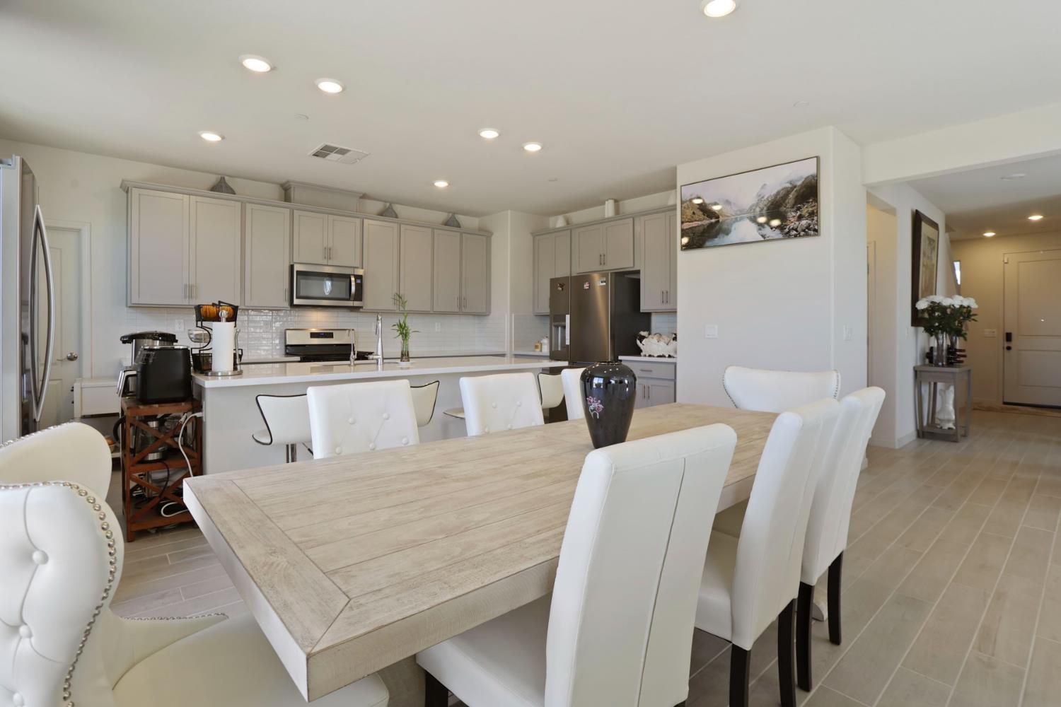 6949 Foraker Drive Stockton, CA 95219 - Photo 11 of 34 a large kitchen with stainless steel appliances kitchen island granite countertop a dining table chairs and a refrigerator