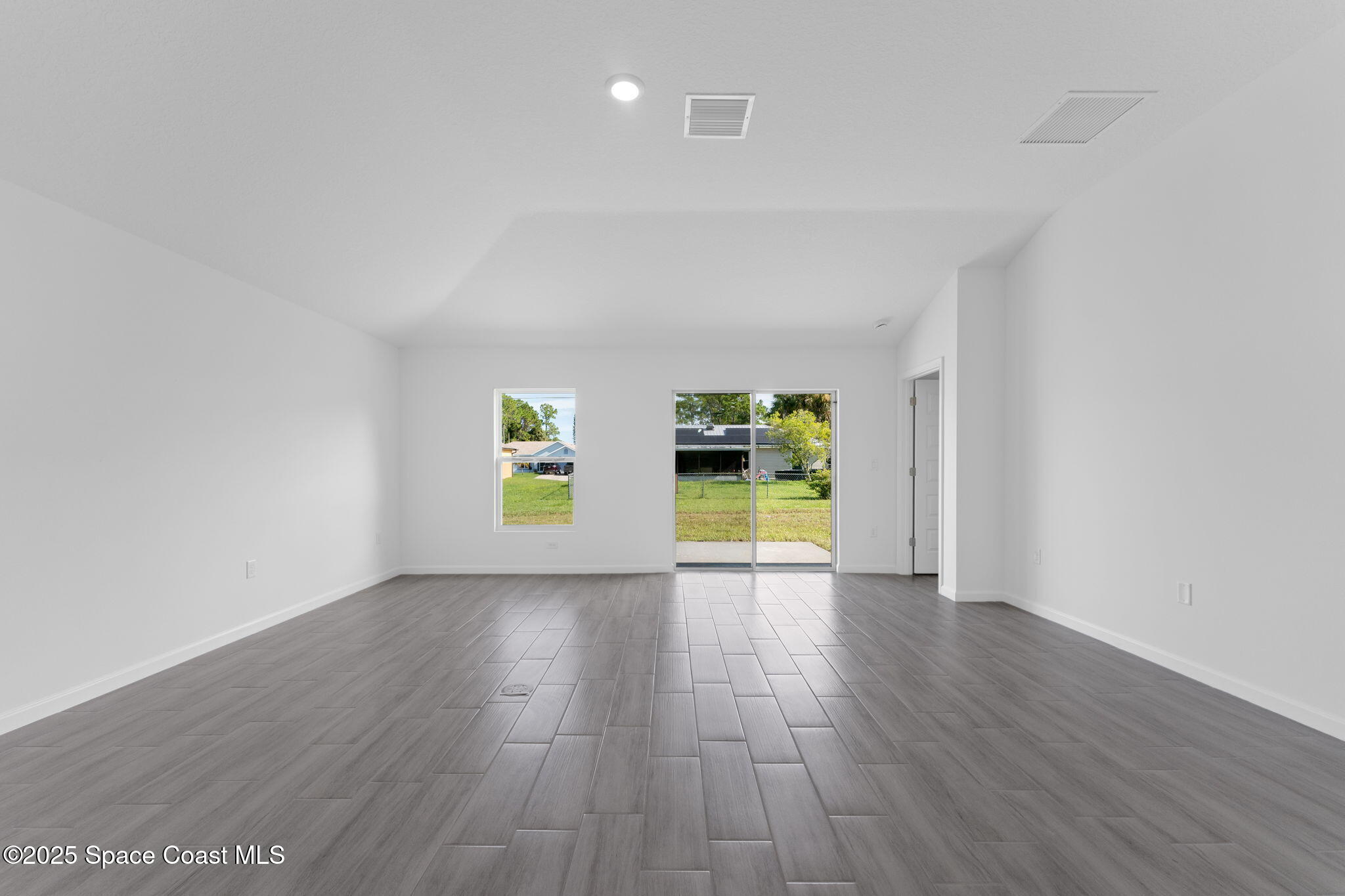 101 Crosspoint Street Southeast Palm Bay, FL 32909 - Photo 15 of 28 a view of an empty room with a window and wooden floor