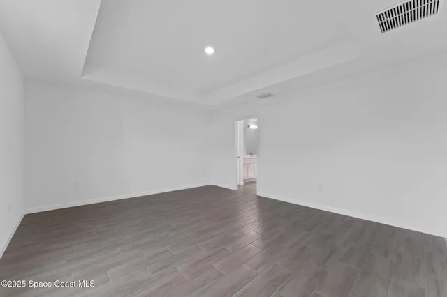 a view of an empty room with wooden floor