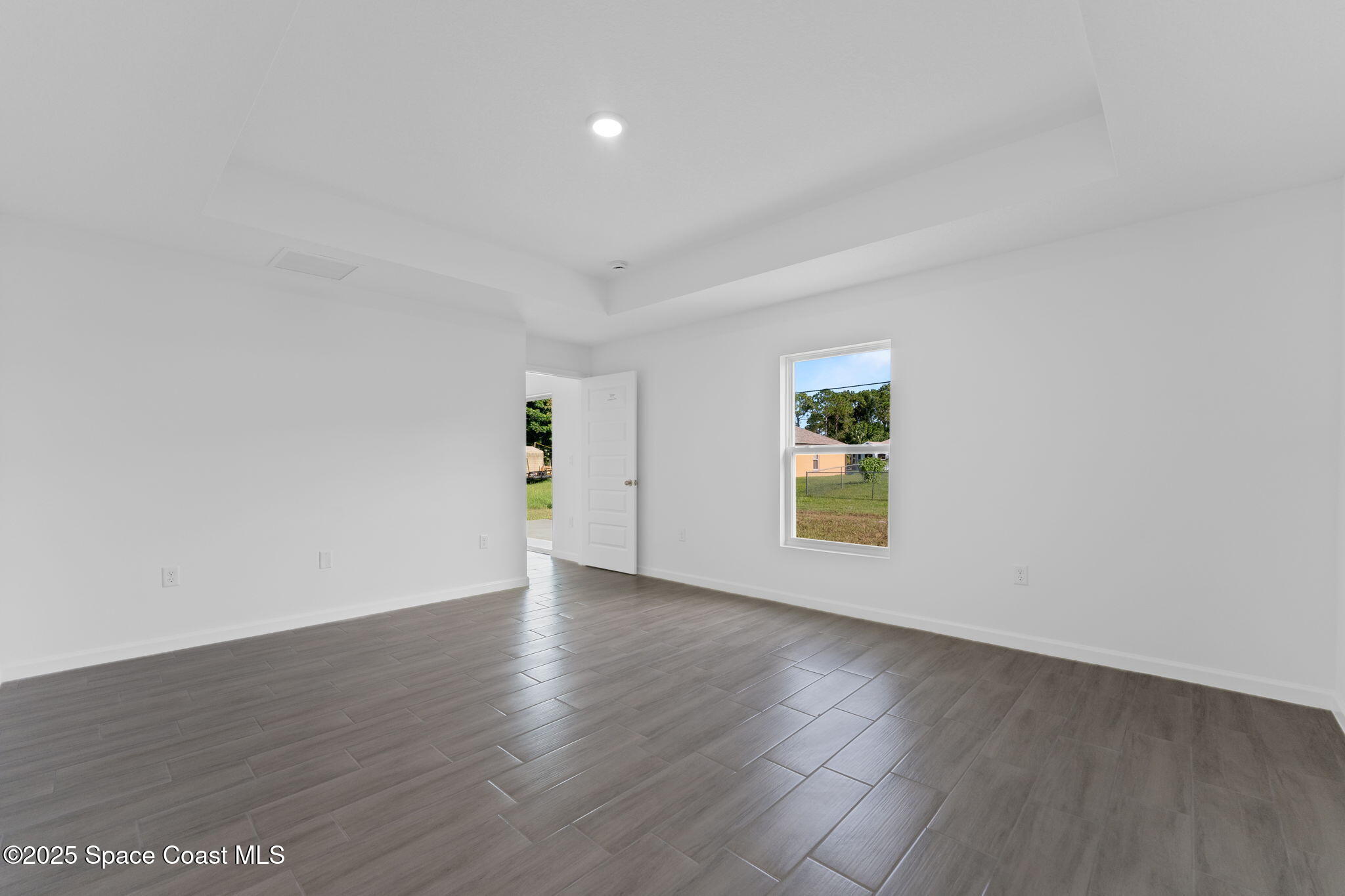 101 Crosspoint Street Southeast Palm Bay, FL 32909 - Photo 17 of 28 an empty room with wooden floor and windows