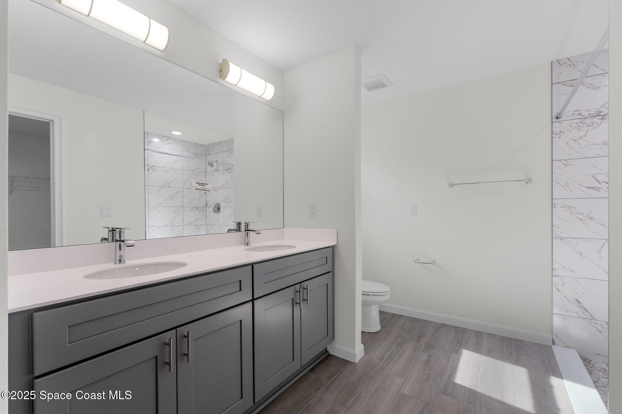 101 Crosspoint Street Southeast Palm Bay, FL 32909 - Photo 18 of 28 a bathroom with a double vanity sink toilet and a mirror