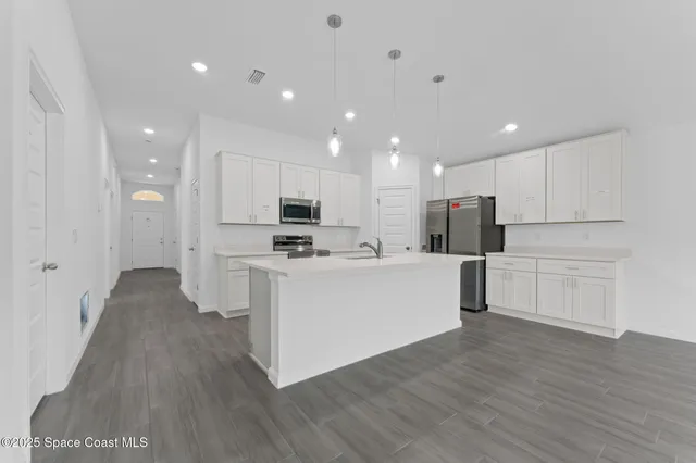 a view of kitchen with cabinets microwave and stove