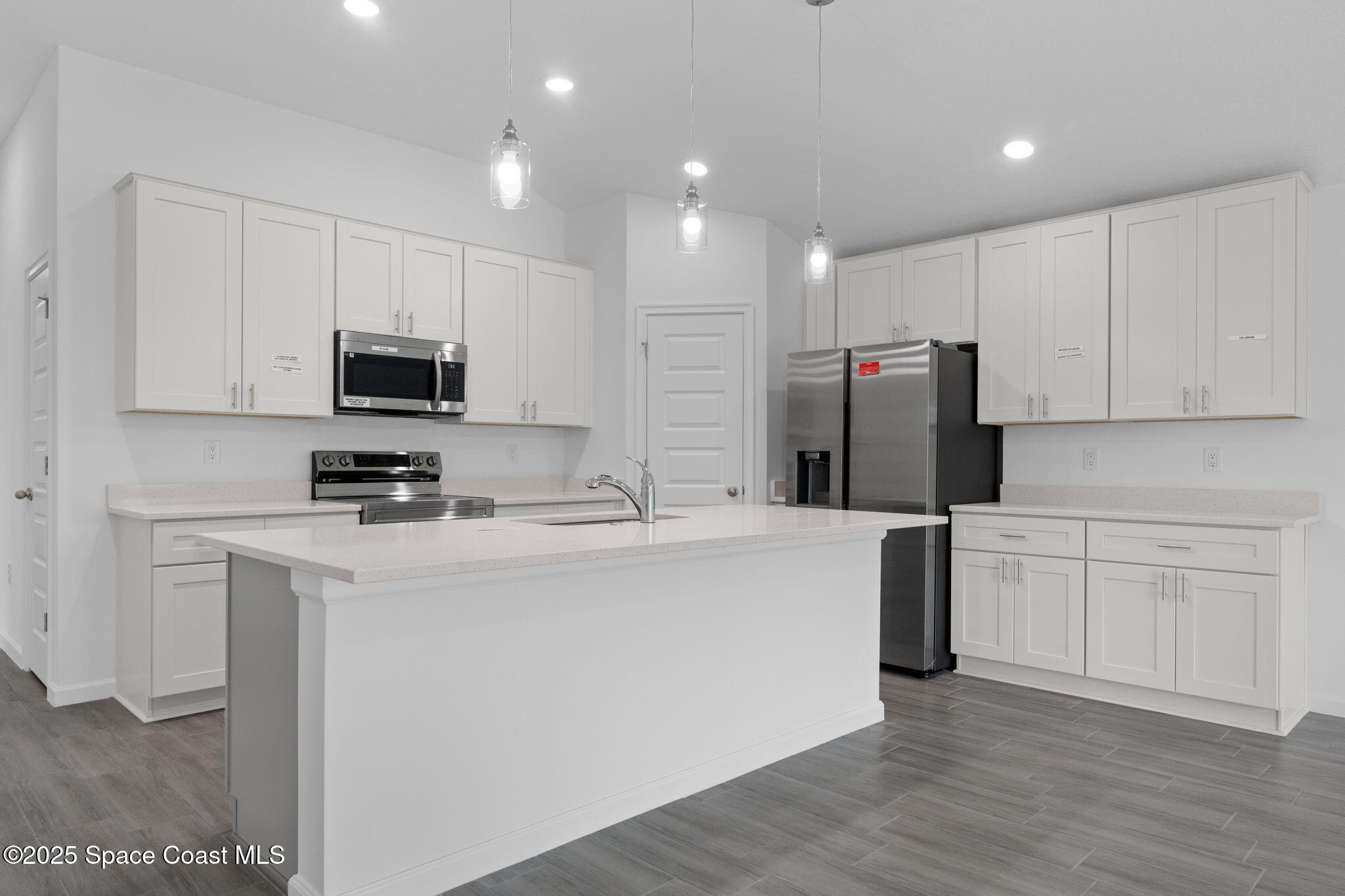 101 Crosspoint Street Southeast Palm Bay, FL 32909 - Photo 4 of 28 a kitchen with stainless steel appliances a refrigerator stove microwave and sink