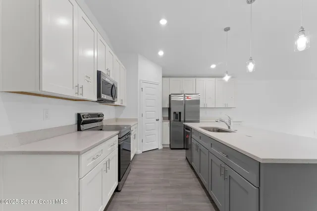 a kitchen with stainless steel appliances kitchen island granite countertop a sink and cabinets