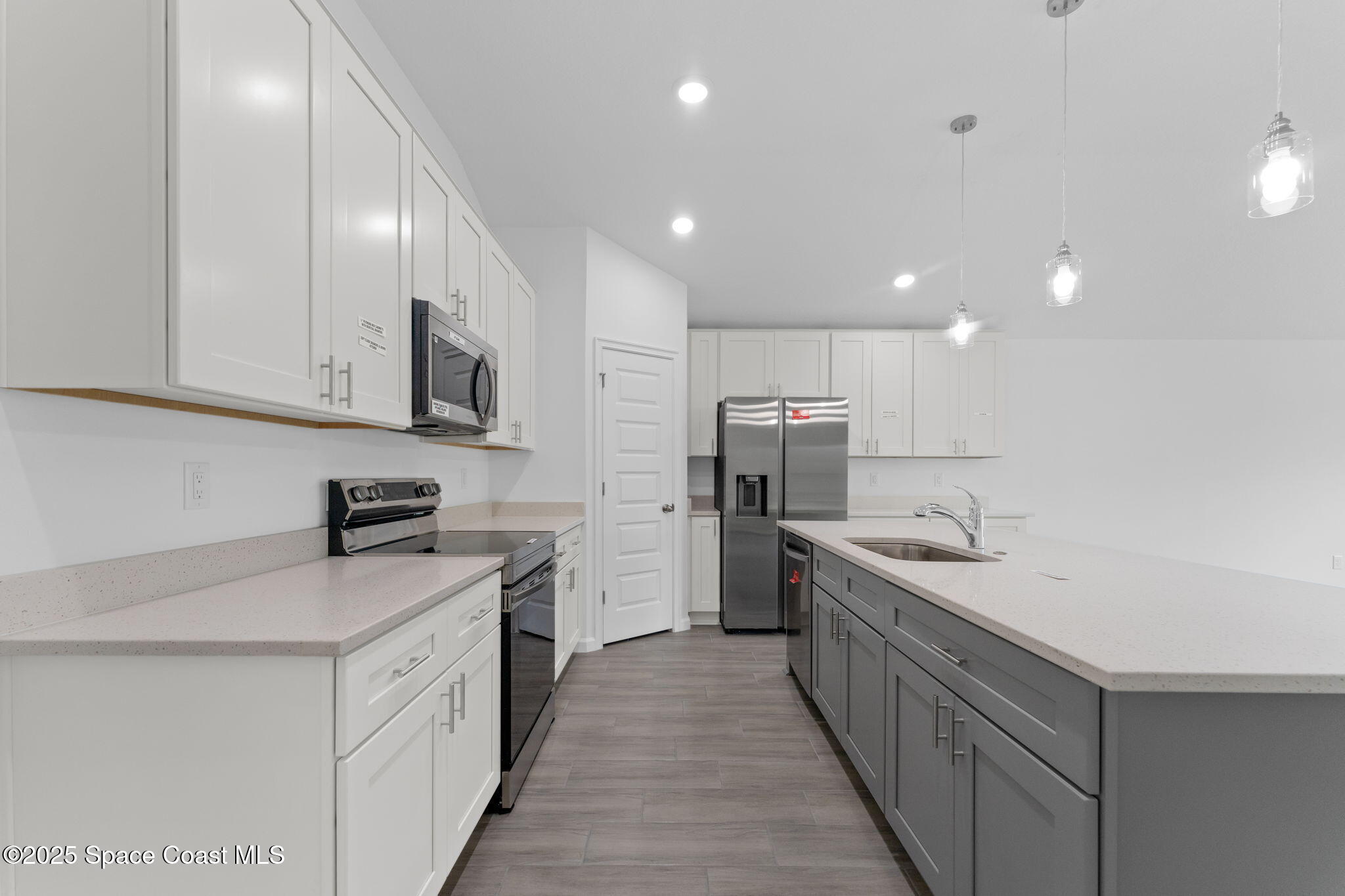 101 Crosspoint Street Southeast Palm Bay, FL 32909 - Photo 5 of 28 a kitchen with stainless steel appliances kitchen island granite countertop a sink and cabinets