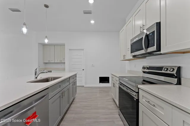 a kitchen with stainless steel appliances a sink stove top oven and microwave