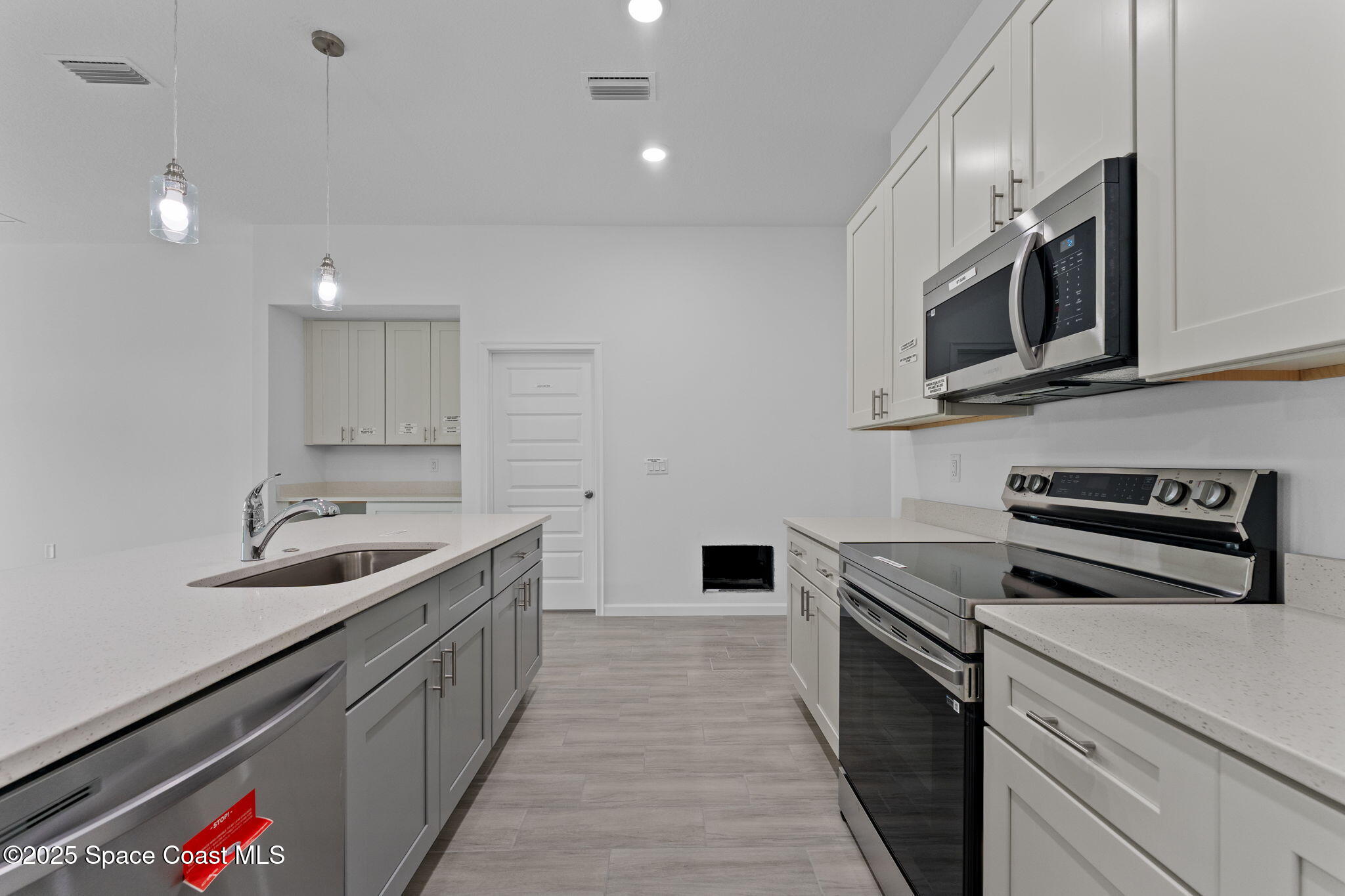 101 Crosspoint Street Southeast Palm Bay, FL 32909 - Photo 6 of 28 a kitchen with stainless steel appliances a sink stove top oven and microwave