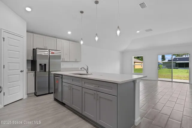 a kitchen with kitchen island a sink a stove and refrigerator