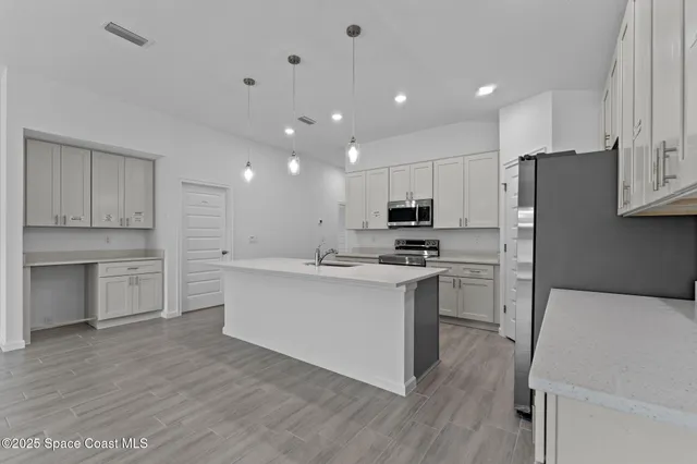 a kitchen with white cabinets and stainless steel appliances